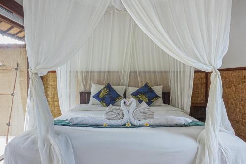 two swans sitting on top of a bed at Made Taro - Menjangan Homestay in Banyuwedang