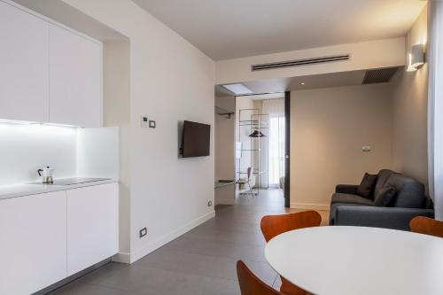 a kitchen and a living room with a table and chairs at Hotel Verona in Verona