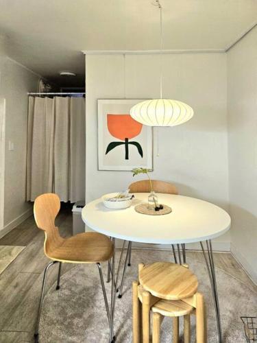 Un comedor con una mesa y sillas blancas. en Swoonstay Netflix Free Coffee, en Seúl