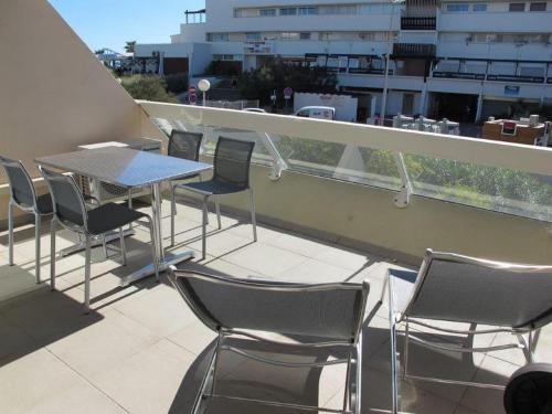 - un balcon avec une table et des chaises dans l'établissement Studio Miroir - Héliopolis D 72 - Luxe - 4 personnes, au Cap d'Agde