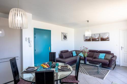 un salon avec une table en verre et un canapé dans l'établissement Appart Villa Margaux proche mer, à Les Sables-dʼOlonne