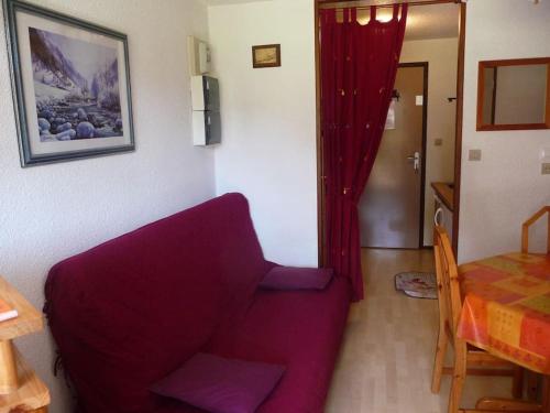 un salon avec un canapé violet et une table dans l'établissement Appartement face à la montagne, à Abondance