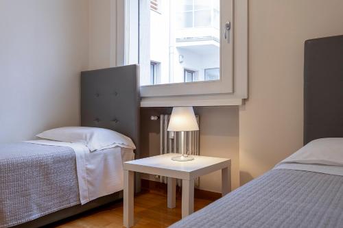 a bedroom with two beds and a table with a lamp at Hotel Verona in Verona