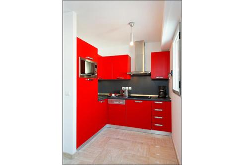 - une cuisine rouge avec des placards rouges et un évier dans l'établissement Sunlight Properties - Bugatti - Beausoleil, France 1 Bedroom, stunning holiday rental apartment with balcony, à Beausoleil
