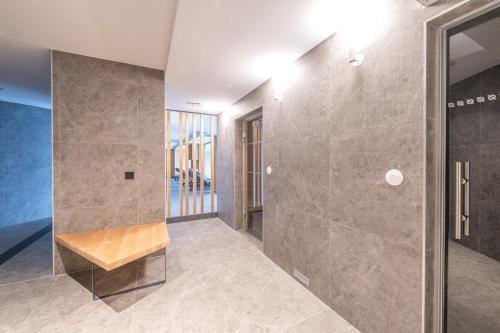 La salle de bains est pourvue d'une douche et d'un banc. dans l'établissement BlancPhoenix, à L'Alpe-d'Huez
