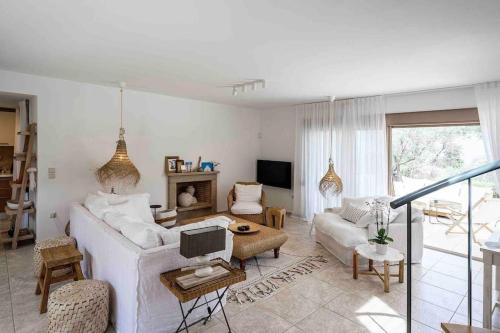 un soggiorno con un divano e un tavolo di Stylish Pool Villa Konstantinidis Complex a Hanioti