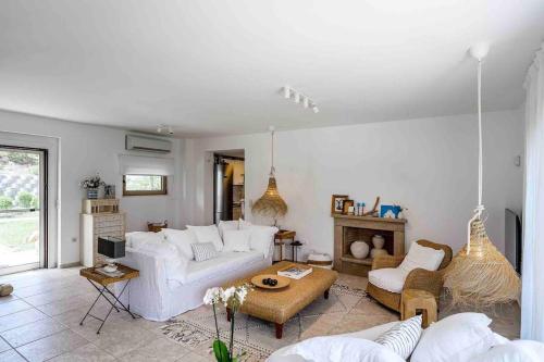 un soggiorno con divani bianchi e tavolo di Stylish Pool Villa Konstantinidis Complex a Hanioti