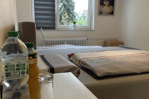 Zimmer mit 2 Betten und einer Flasche Wasser auf dem Tisch in der Unterkunft Private Rooms in Hannover
