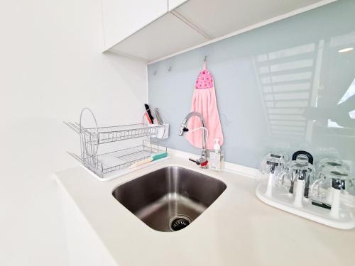 a white kitchen with a sink and a counter at Duplex Eko Cheras Kuala Lumpur City Center Tun Razak Exchange Mall in Kuala Lumpur