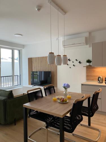 a kitchen and living room with a wooden table and chairs at Alpine Haven in Bovec