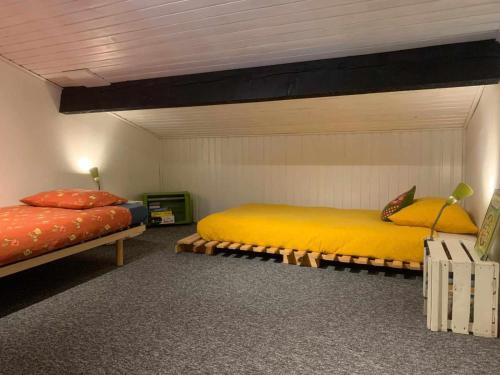een slaapkamer met 2 bedden in een kamer bij L'App'Art des Ateliers Gerny in Humain