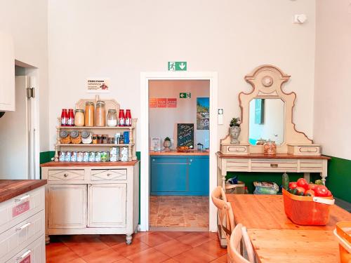 a kitchen with a table and a mirror at Ostello Bello Firenze in Florence