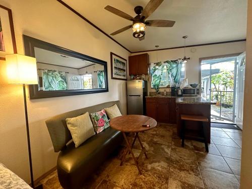 Hawaiian Ohana Home في هيلو: غرفة معيشة مع أريكة وطاولة