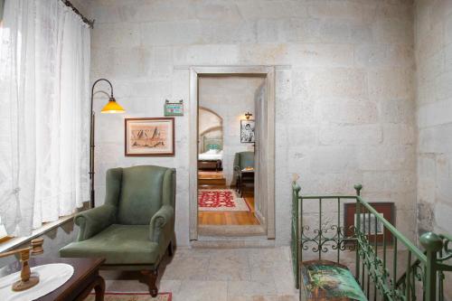 a living room with a green chair and a hallway at Terra Cave Hotel in Goreme