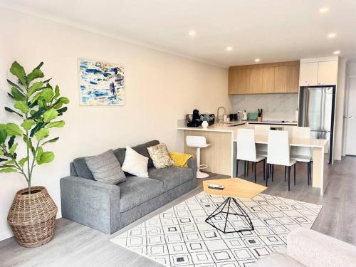 a living room with a couch and a kitchen at Nice New 3 bedroom Townhouse U4 in Hamilton