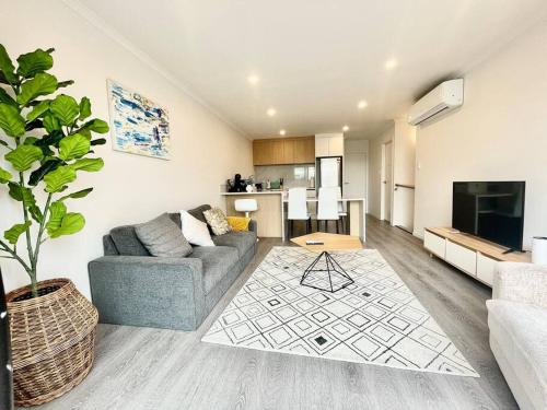 a living room with a couch and a kitchen at Nice New 3 bedroom Townhouse U4 in Hamilton