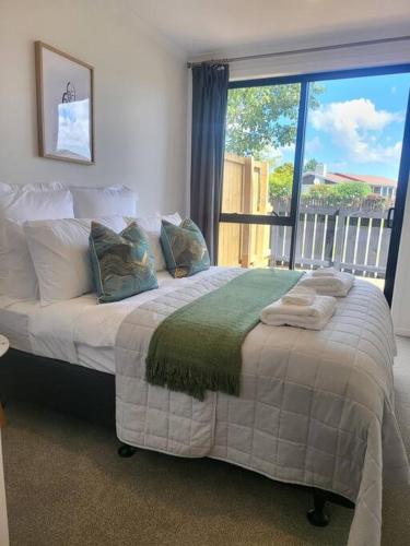 a bed in a room with a large window at Nice New 3 bedroom Townhouse U4 in Hamilton