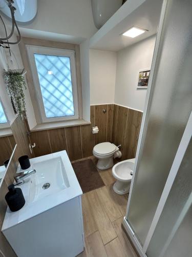 a bathroom with a sink and a toilet and a window at Accogliente Dimora in centro storico Alvito 1 Bedr in Alvito