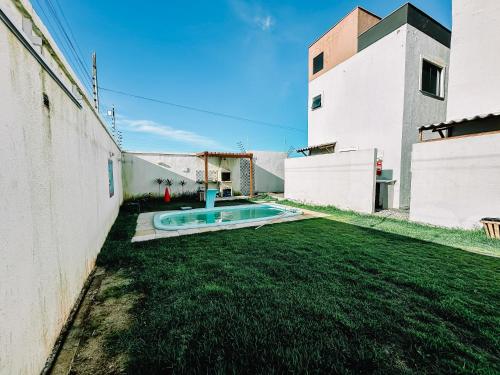 a yard with a swimming pool in the middle of a building at Casa Amar Cumbuco in Cumbuco