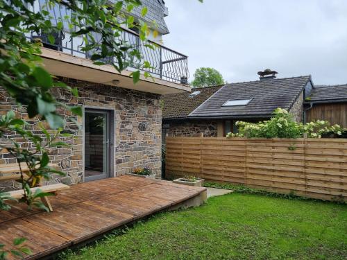 a wooden deck in the yard of a house at Appartement chez Nanou in Stoumont