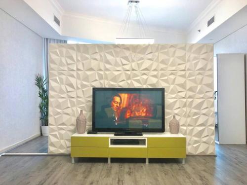 a flat screen tv sitting on top of a yellow cabinet at Fabulous Residential Private Apartment Upgraded Full Sea & Mangrove Views Abu Dhabi - Not Hotel - 1106 in Abu Dhabi