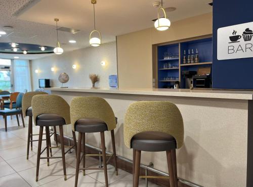 un bar avec des chaises et un comptoir dans un restaurant dans l'établissement Domitys La Rose des Vents, à Saint-Gilles-Croix-de-Vie