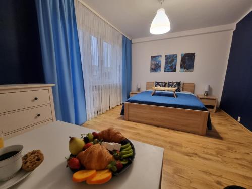 a bedroom with a bed and a bowl of fruit on a table at Pokoje Częstochowa in Częstochowa
