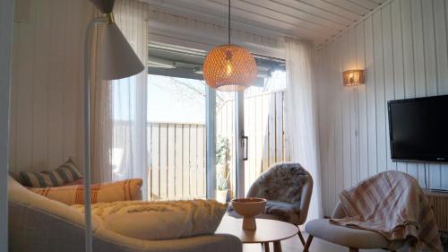 a living room with a couch and chairs and a television at Sommerstua - Nes Camping in Moss