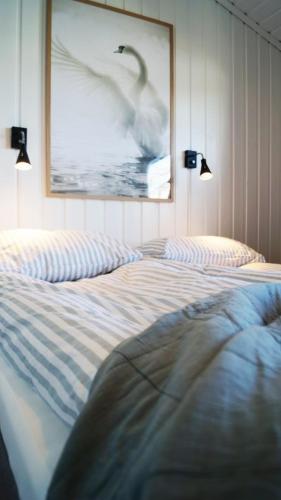 a bedroom with a bed and a picture of a swan at Sommerstua - Nes Camping in Moss