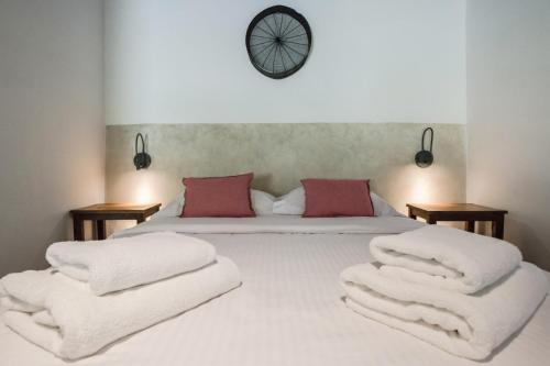 a bedroom with a bed with white blankets and a clock at Μilia Mountain retreat in Vlátos