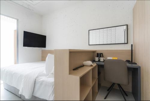 een slaapkamer met een bed en een bureau met een telefoon bij Homes Stay G-Valley Gasan in Seoul
