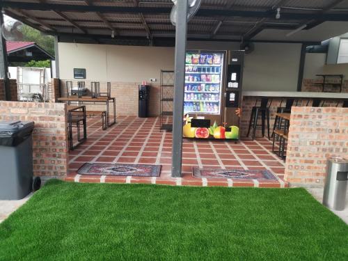 a patio with green grass and a drink machine at Anjung Barakah Chalet in Kuala Terengganu
