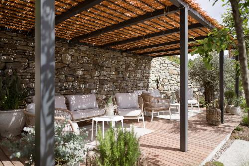 patio con divani e sedie sotto un pergolato in legno di Feel good Resort Johannis a Tirolo
