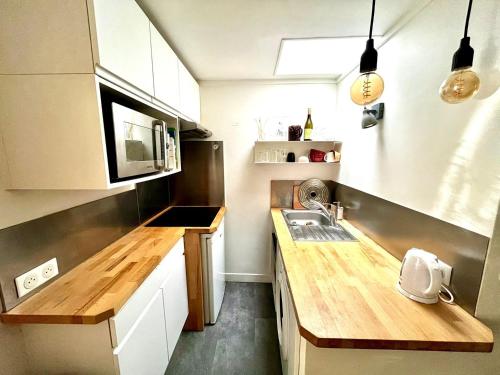 une petite cuisine avec un comptoir et un évier dans l'établissement Le perchoir - Charmant & Lumineux - Bastille, à Paris