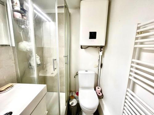 une petite salle de bain avec toilettes et douche dans l'établissement Le perchoir - Charmant & Lumineux - Bastille, à Paris