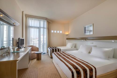 Habitación de hotel con cama grande y TV en Green Max Hotel en Belek