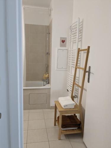 une salle de bain avec une échelle, une baignoire et une chaise dans l'établissement Spacieux Duplex, à Villejuif