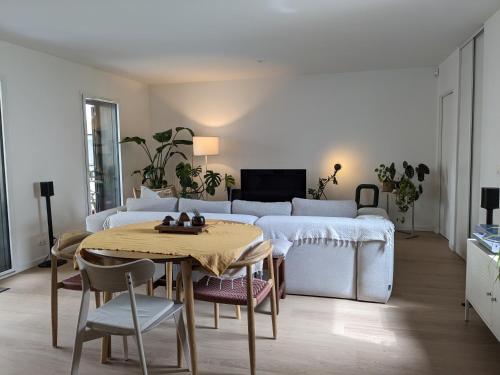un salon avec une table et un canapé dans l'établissement Spacieux Duplex, à Villejuif