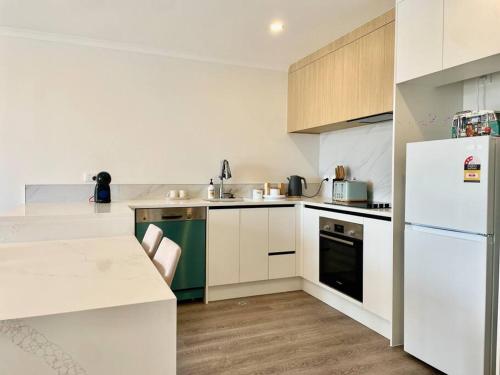 a kitchen with white cabinets and a white refrigerator at Nice 3 bedrooms Townhouse U5 in Hamilton