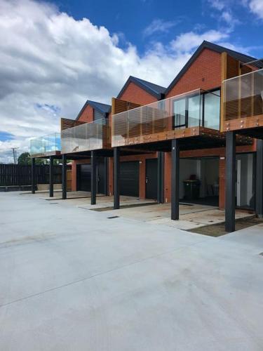 a red brick building with glass windows on it at Nice 3 bedrooms Townhouse U5 in Hamilton