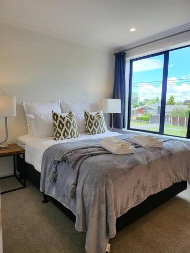 a bedroom with a large bed with a large window at Nice 3 bedrooms Townhouse U5 in Hamilton
