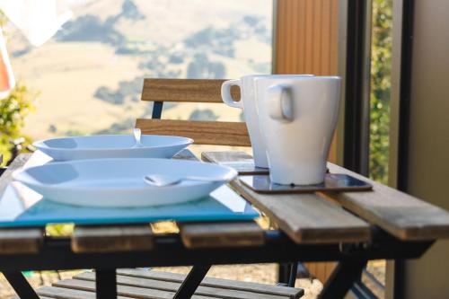 a table with two bowls and a coffee cup on it at Kūkupa Puni at Akaroa Lavender by Tiny Away in Akaroa