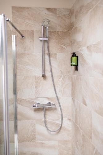 a shower with a shower head in a bathroom at Stonehenge Courtyard in Amesbury