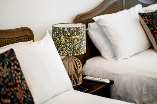 a lamp on a night stand next to two beds at Stonehenge Courtyard in Amesbury