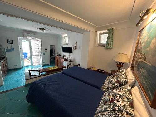 ein Schlafzimmer mit einem blauen Bett und ein Wohnzimmer in der Unterkunft AUGUSTUS PARK Capri Center in Capri