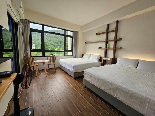 a hotel room with two beds and a table and chairs at Hua Lian Sin Su Homestay in Zhixue