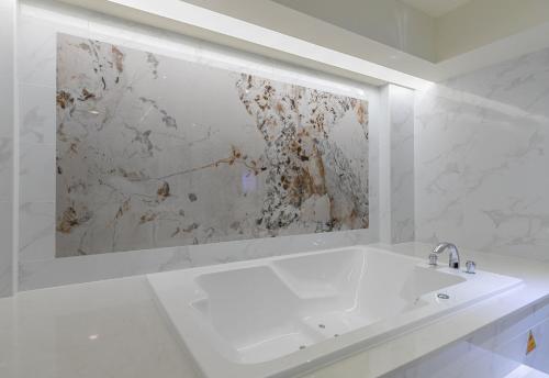 a white bathroom with a sink and a mirror at 里萊行旅 - Lilai Motel in Taoyuan