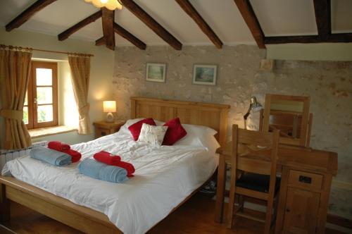 a bedroom with a bed with red and blue pillows at Nandolle Farmhouse in Nanteuil-de-Bourzac