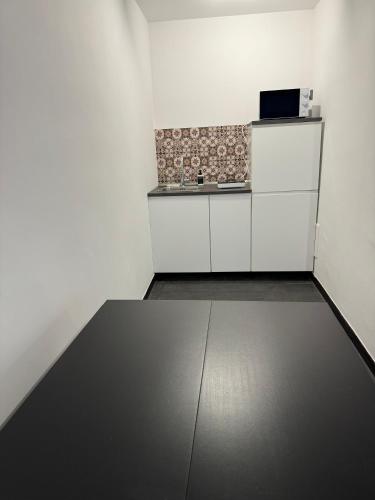 a white kitchen with a counter and a microwave at Black Room & Breakfast in Bari