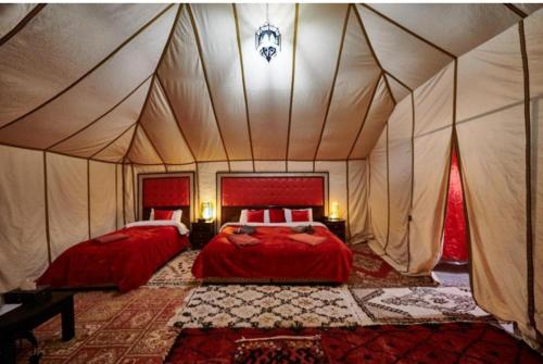 梅爾祖卡的住宿－Merzouga Desert Awaite camp，一间帐篷内带两张床的卧室